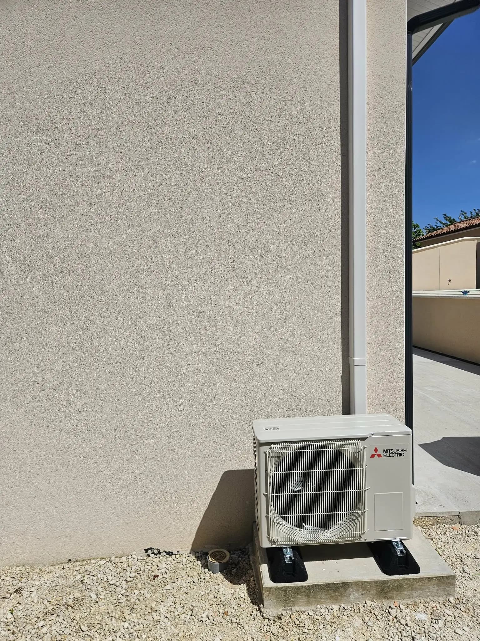 Unité extérieure Mitsubishi Electric installée par Kevin Faugère sur dalle béton, maison neuve en Dordogne