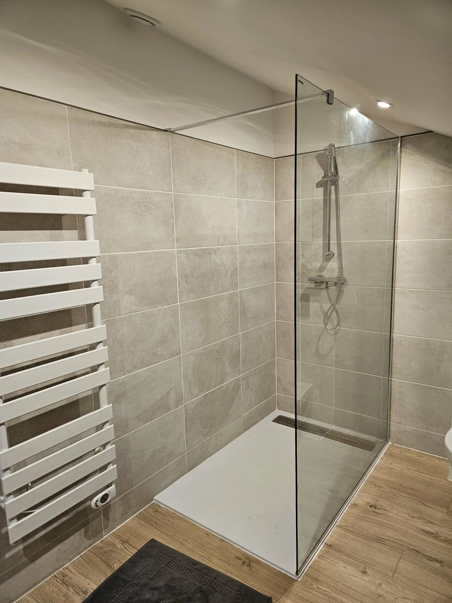 Salle de bain rénovée avec douche à l'italienne et sèche-serviette