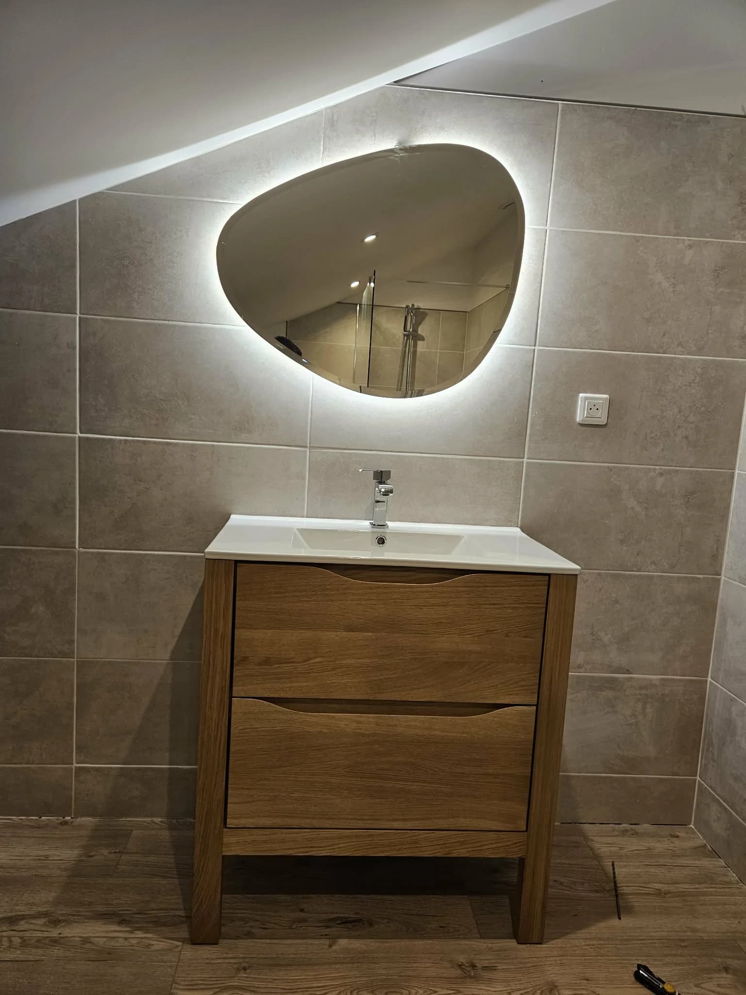 Meuble vasque bois avec miroir LED rétroéclairé dans salle de bain rénovée